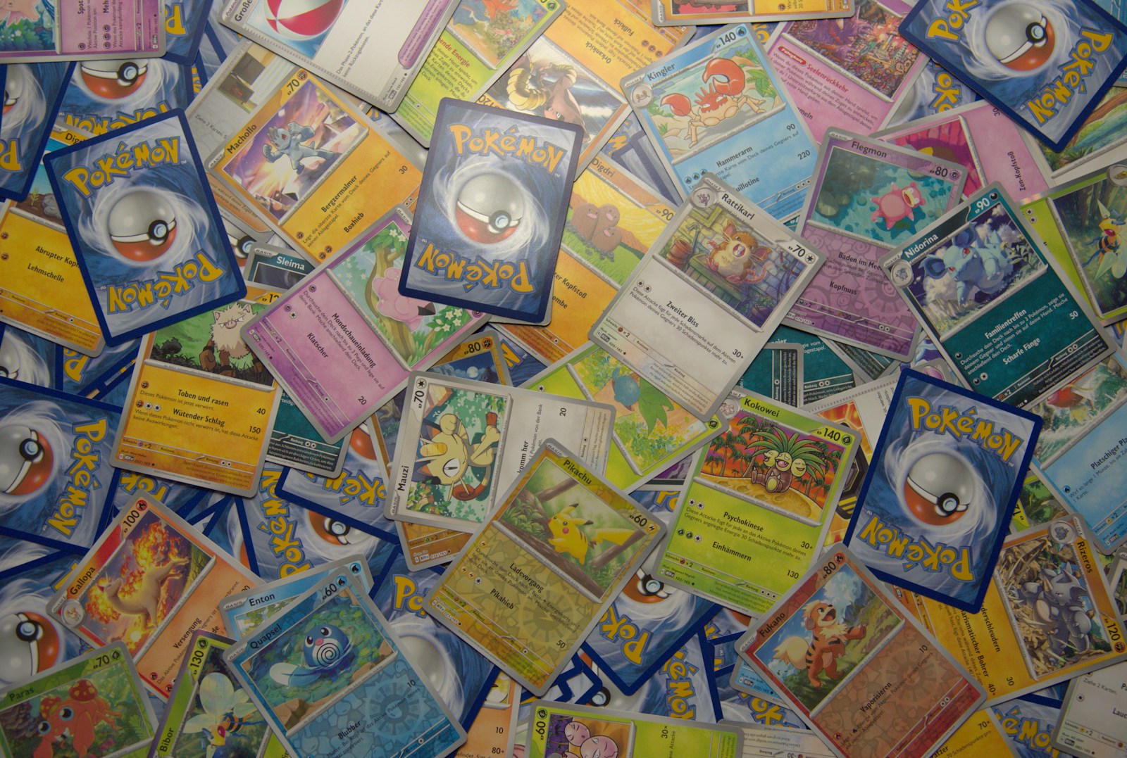 Cartas Pokémon avulsas e versos de cartas sobre uma mesa, em fotografia de Thimo Pedersen